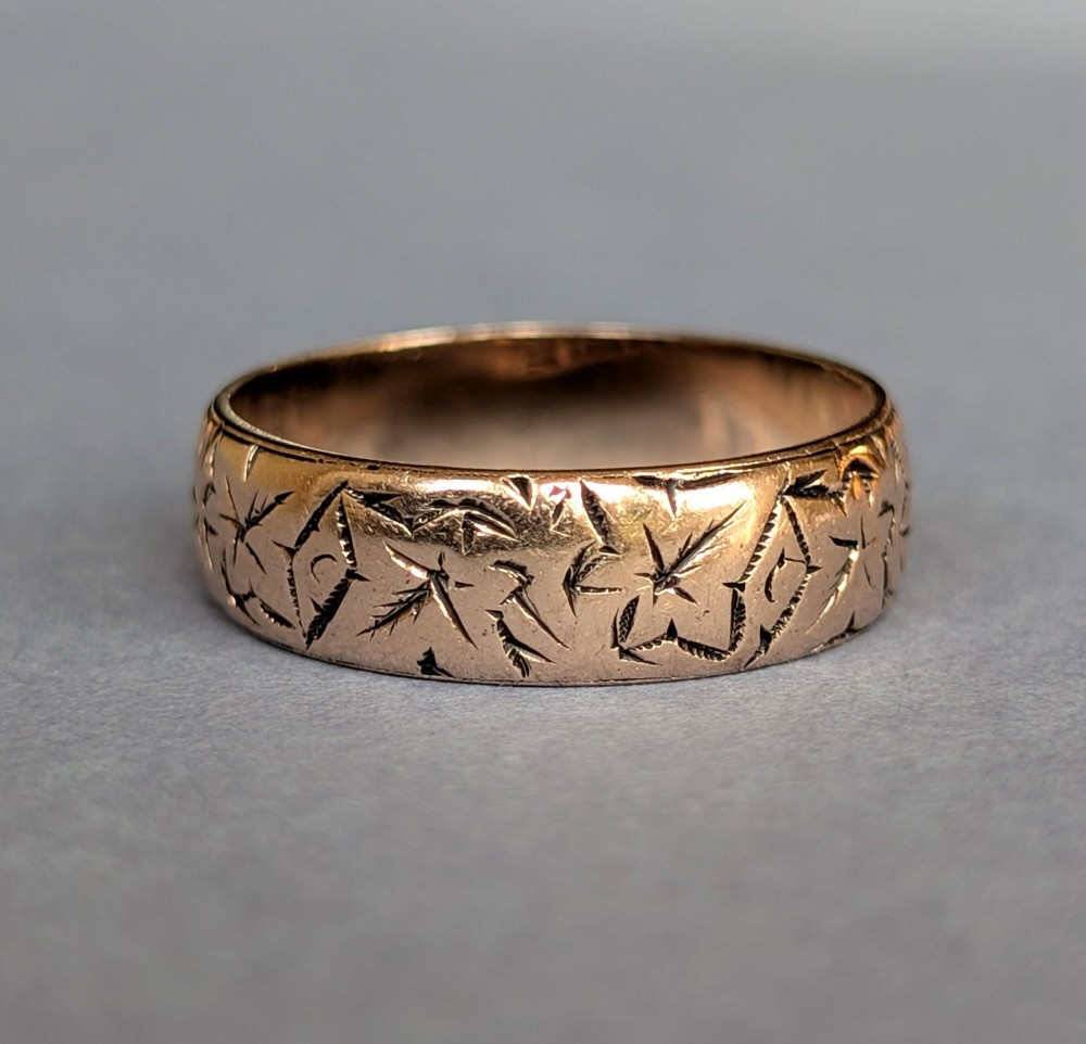 An antique 9ct rose gold wedding band featuring hand-engraved star motifs around the exterior circumference. View II