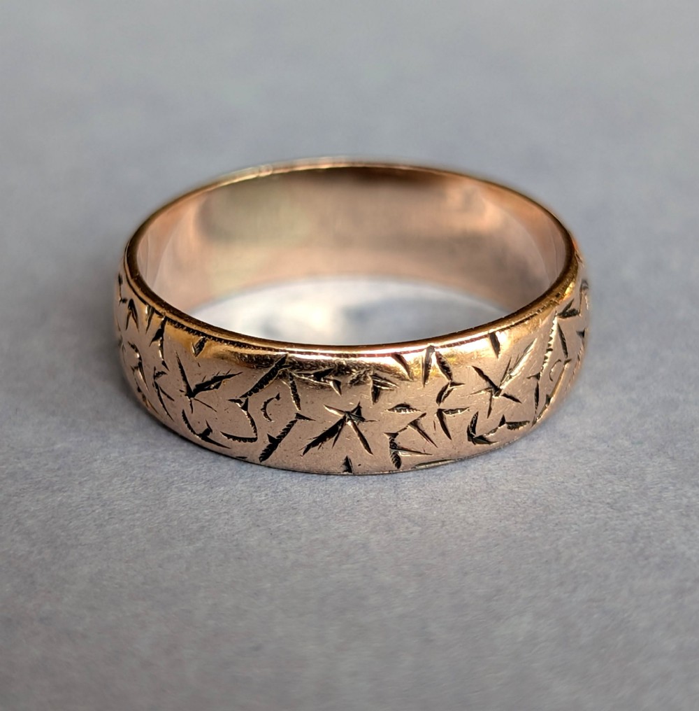 An antique 9ct rose gold wedding band featuring hand-engraved star motifs around the exterior circumference. View III