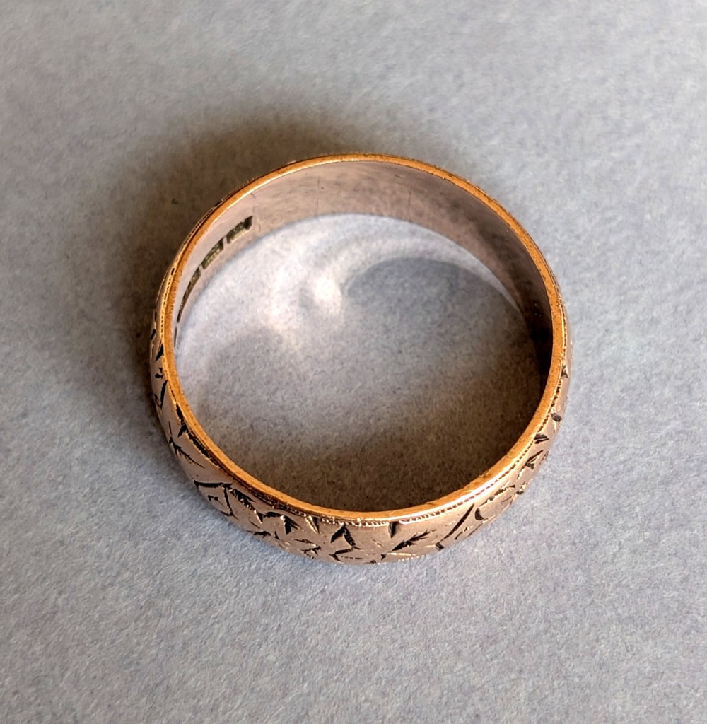 An antique 9ct rose gold wedding band featuring hand-engraved star motifs around the exterior circumference. View IV