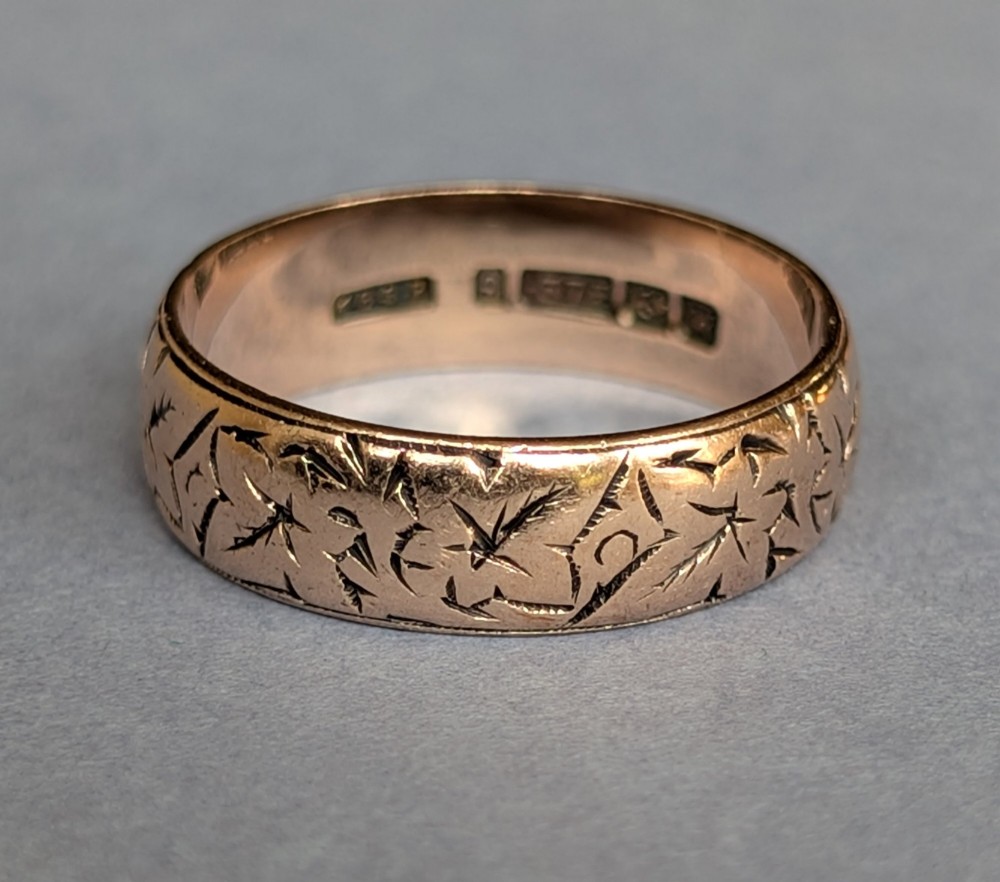 An antique 9ct rose gold wedding band featuring hand-engraved star motifs around the exterior circumference. View VII