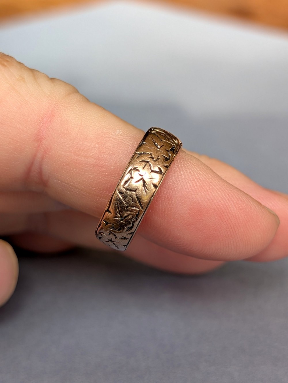 An antique 9ct rose gold wedding band featuring hand-engraved star motifs around the exterior circumference. View VIII