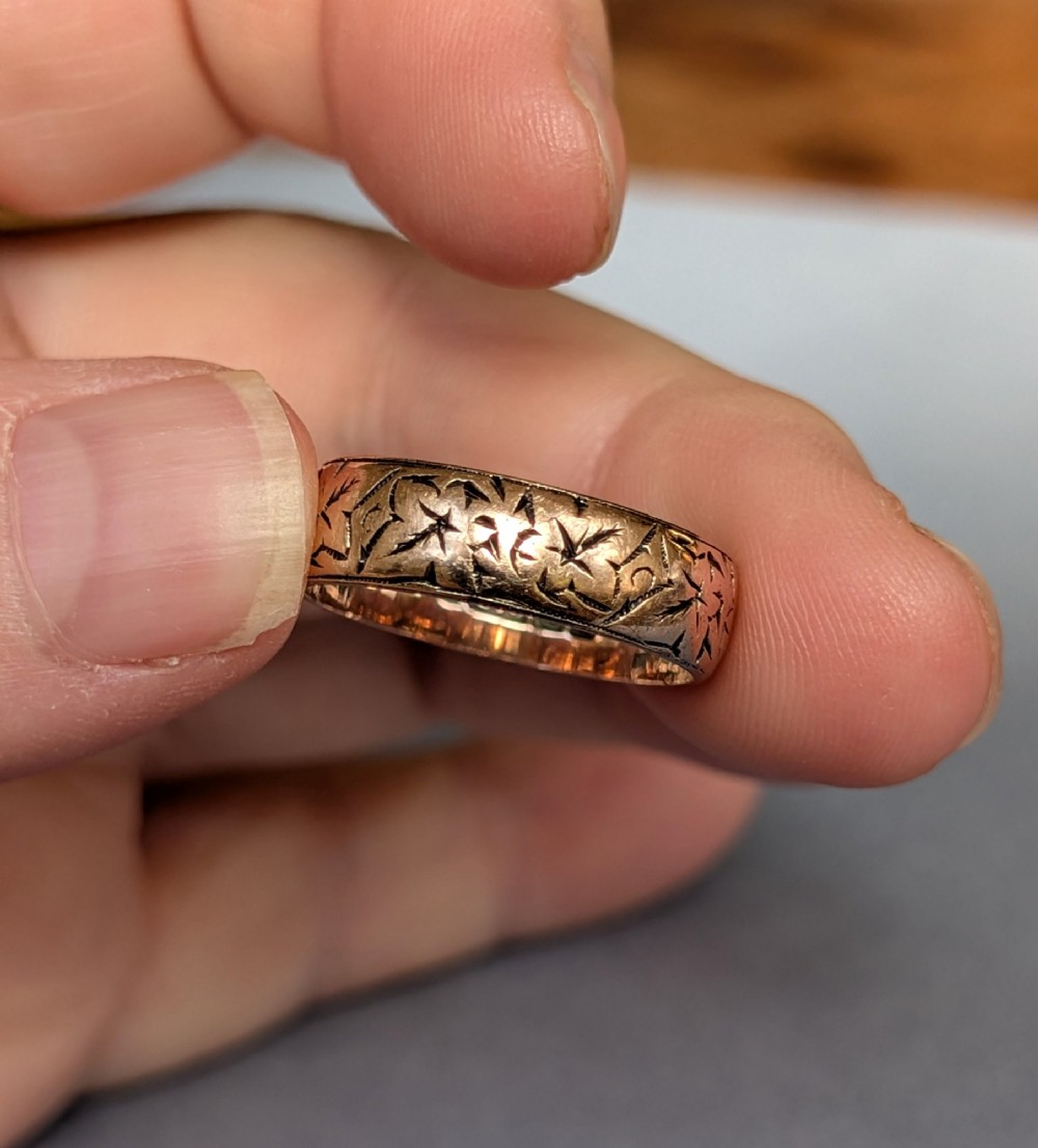 An antique 9ct rose gold wedding band featuring hand-engraved star motifs around the exterior circumference. View IX