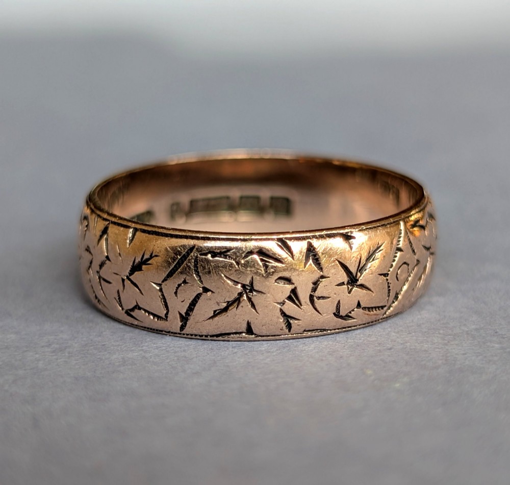 An antique 9ct rose gold wedding band featuring hand-engraved star motifs around the exterior circumference. View XI
