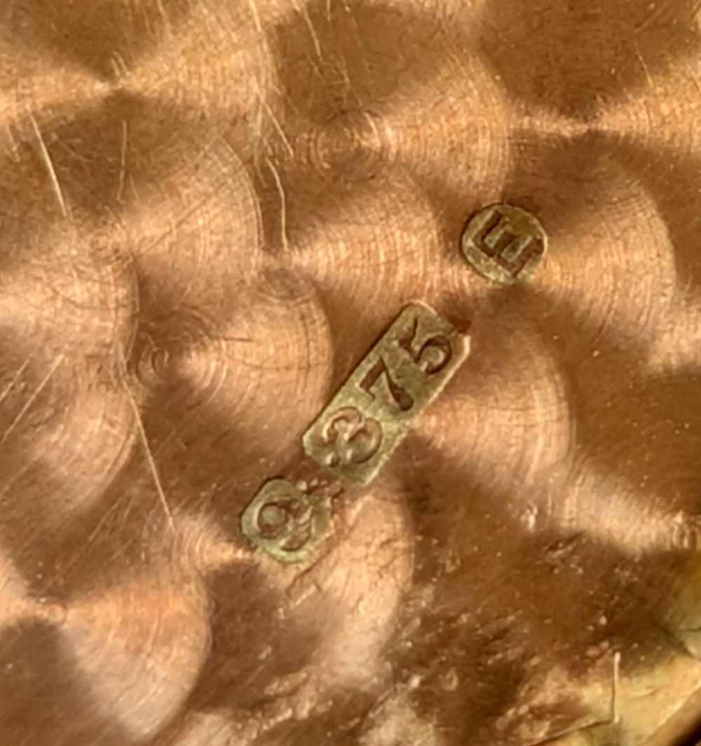 An octagonal 9ct rose gold locket featuring engine-turned geometric engraving suspended from a fine gold chain. View XII