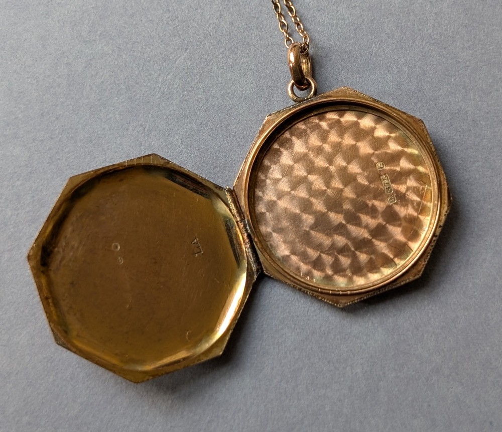 An octagonal 9ct rose gold locket featuring engine-turned geometric engraving suspended from a fine gold chain. View XIII