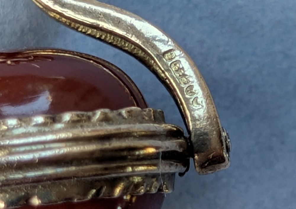 An antique 9ct yellow gold spinning fob pendant set with an oval carnelian cabochon within a swivel mount. View X