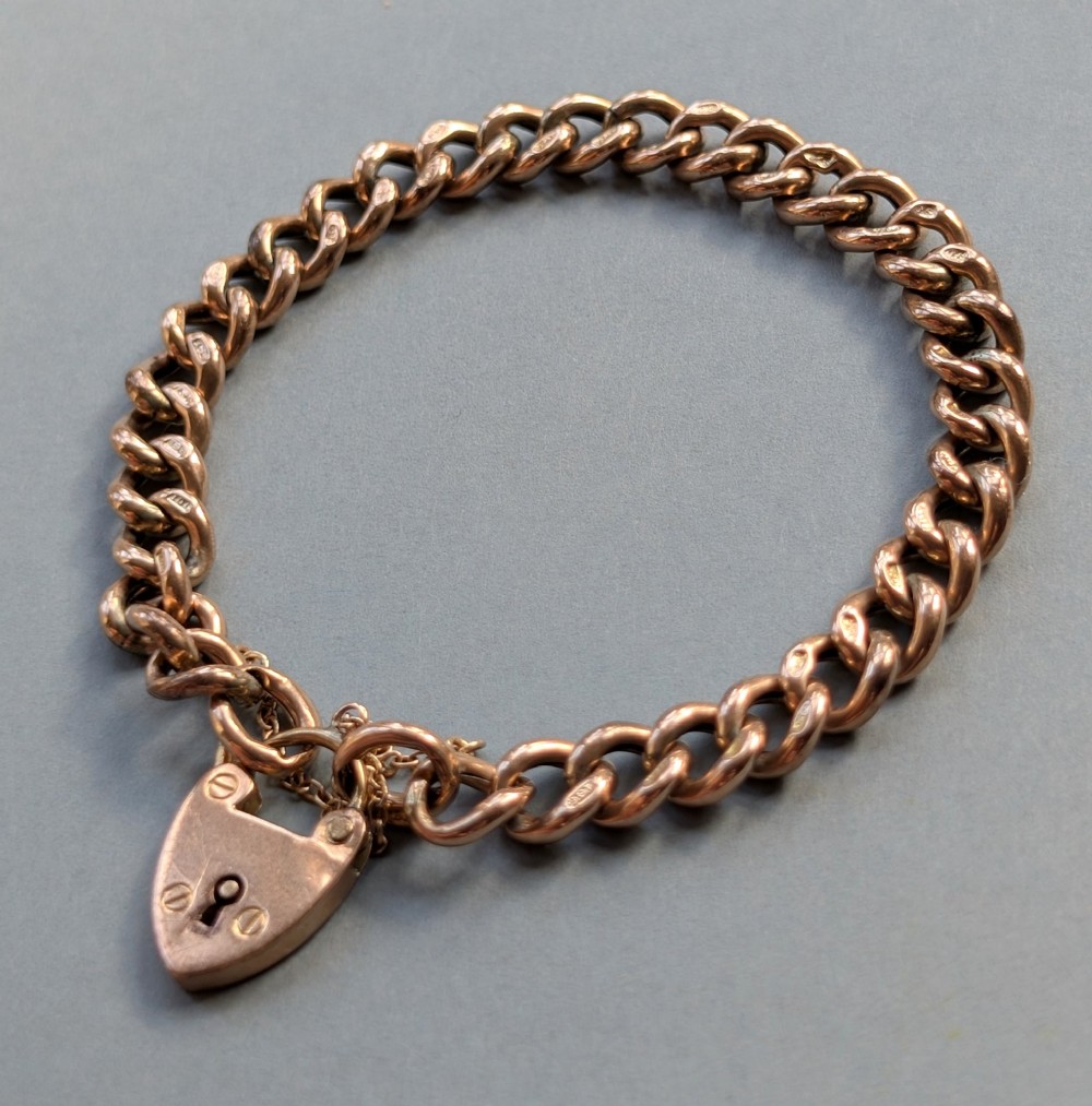 An Edwardian 9ct rose gold curb link chain bracelet featuring a heart-shaped padlock clasp and safety chain. View III