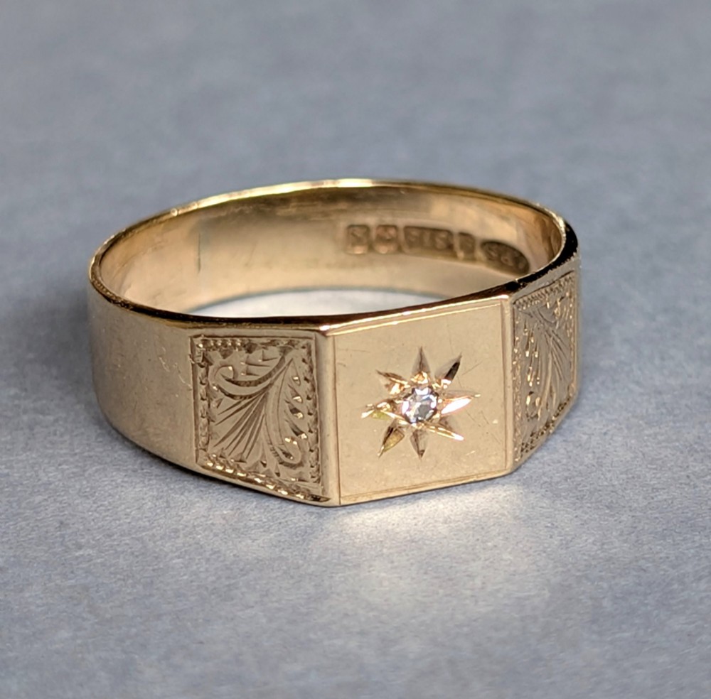 A vintage 9ct yellow gold gents signet ring featuring a star-set central stone and foliate engraved shoulders. View III