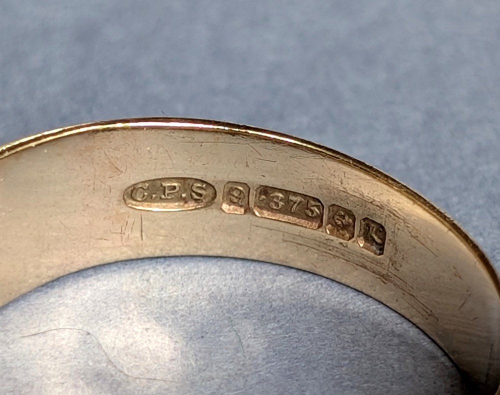 A vintage 9ct yellow gold gents signet ring featuring a star-set central stone and foliate engraved shoulders. View V
