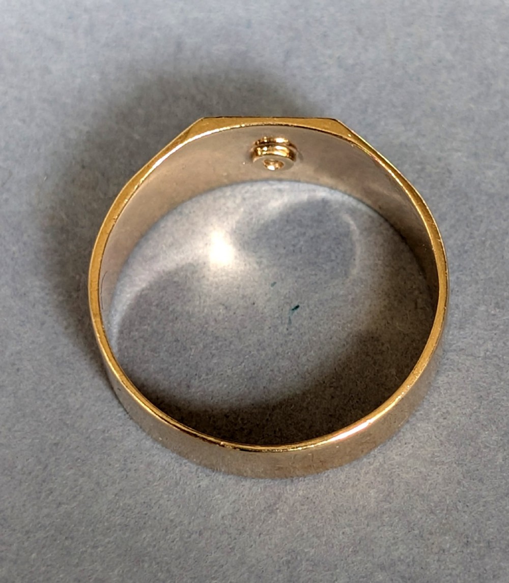 A vintage 9ct yellow gold gents signet ring featuring a star-set central stone and foliate engraved shoulders. View VII