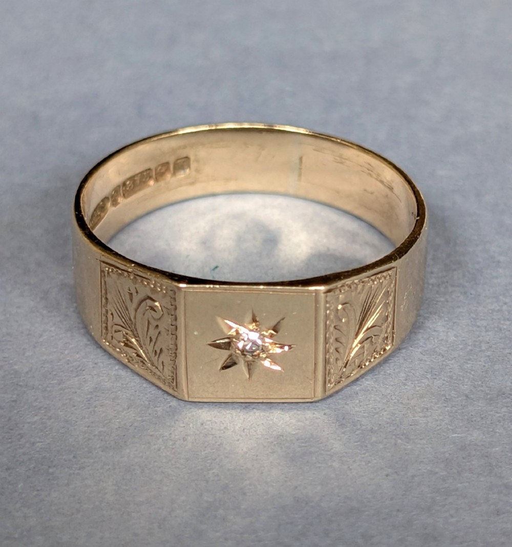 A vintage 9ct yellow gold gents signet ring featuring a star-set central stone and foliate engraved shoulders. View VIII