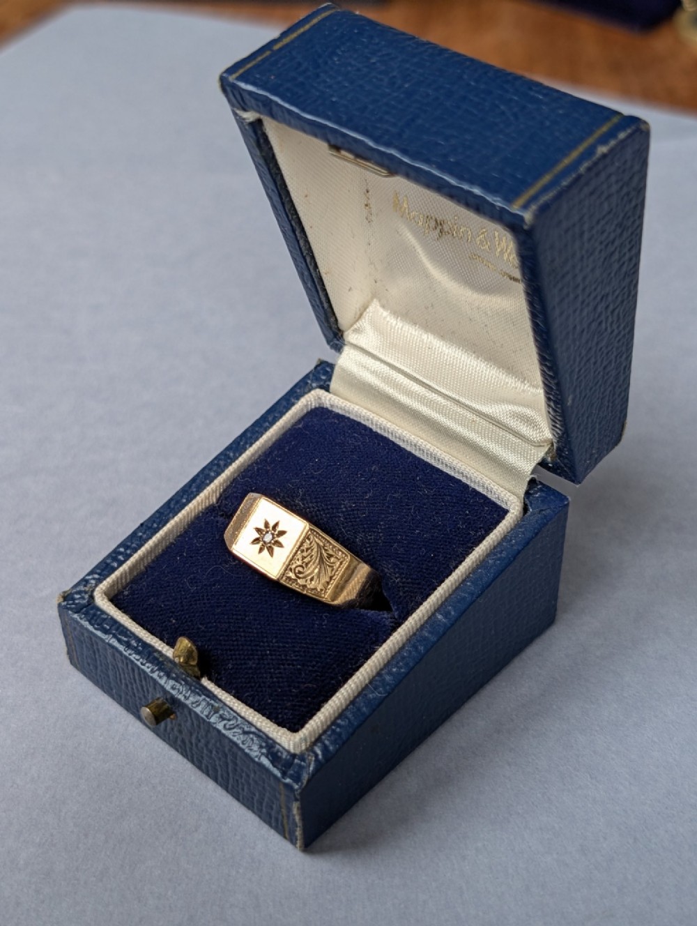 A vintage 9ct yellow gold gents signet ring featuring a star-set central stone and foliate engraved shoulders. View XIII