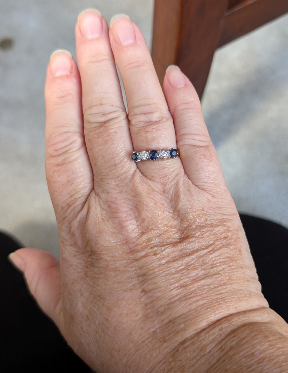An Art Deco five-stone ring featuring three round blue sapphires alternating with two diamonds set in platinum on an 18ct yellow gold band. View XII
