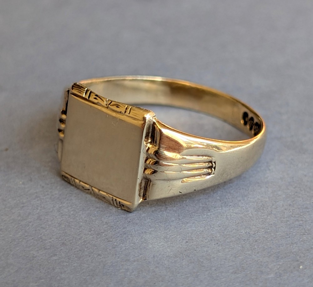 A vintage 9ct yellow gold signet ring featuring a flat square face with decorative engraved top and bottom edges and grooved shoulders. View III