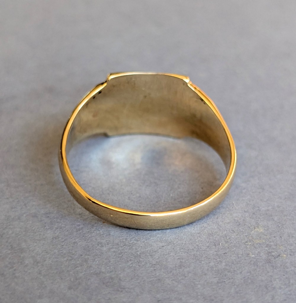 A vintage 9ct yellow gold signet ring featuring a flat square face with decorative engraved top and bottom edges and grooved shoulders. View XI