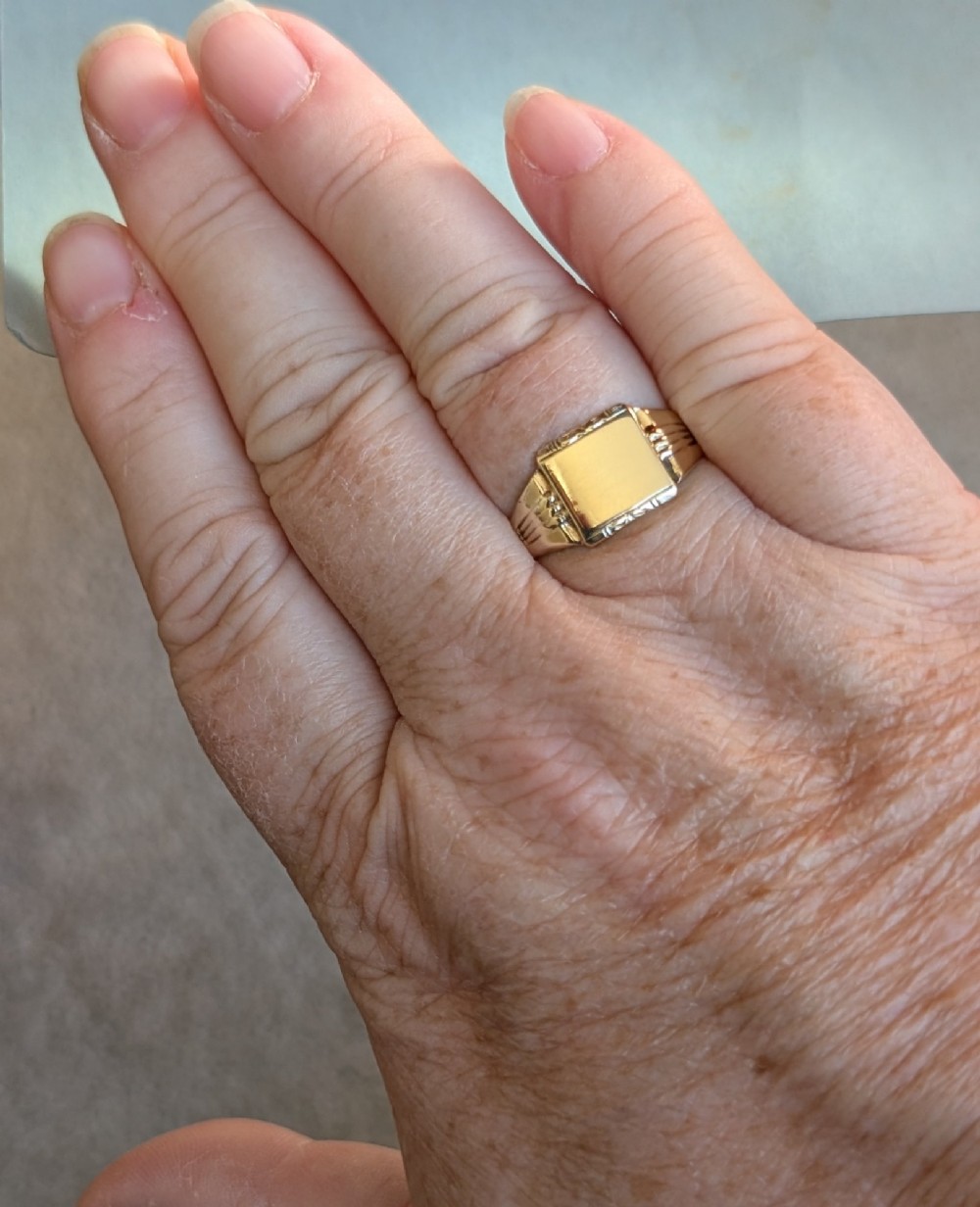 A vintage 9ct yellow gold signet ring featuring a flat square face with decorative engraved top and bottom edges and grooved shoulders. View XIII