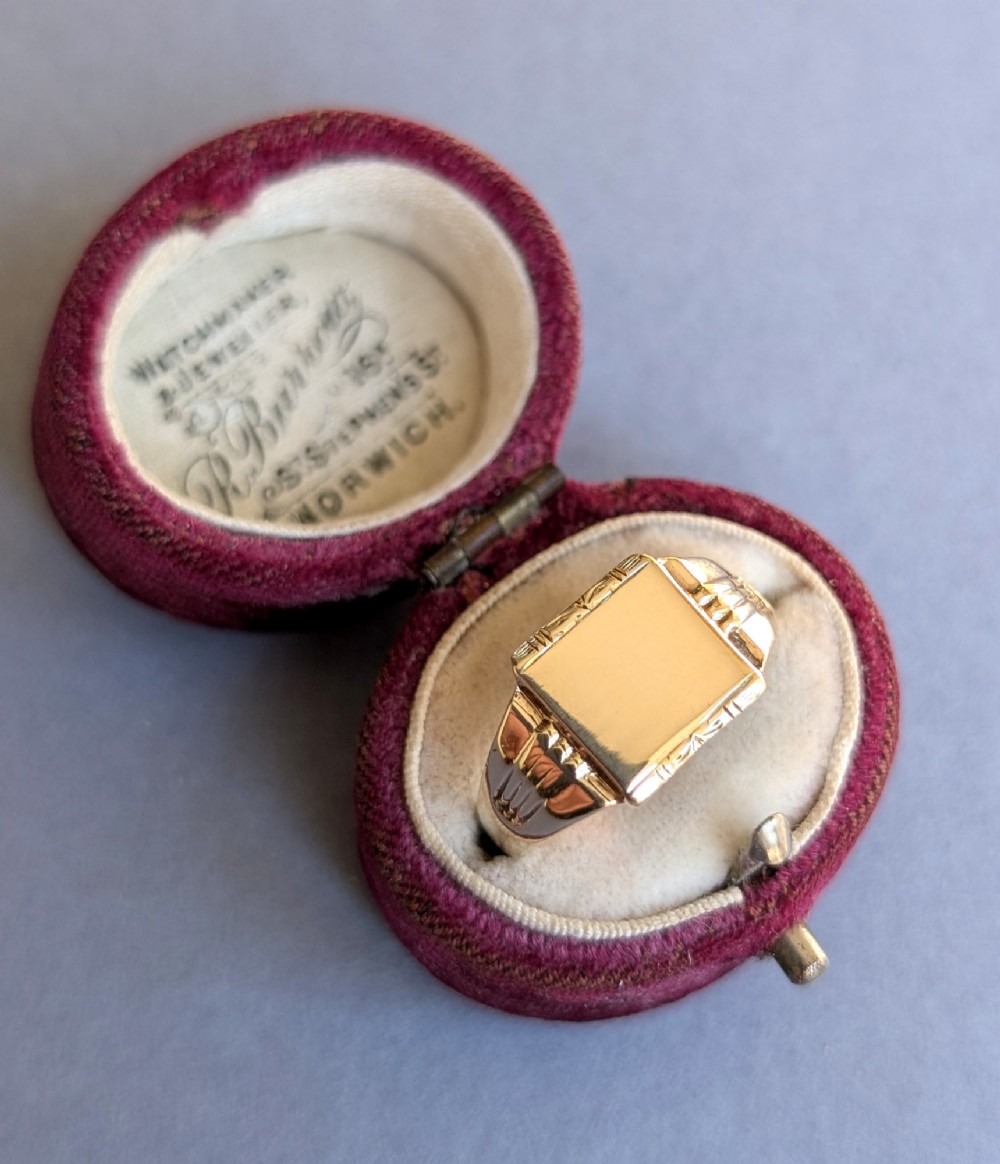 A vintage 9ct yellow gold signet ring featuring a flat square face with decorative engraved top and bottom edges and grooved shoulders. View XV