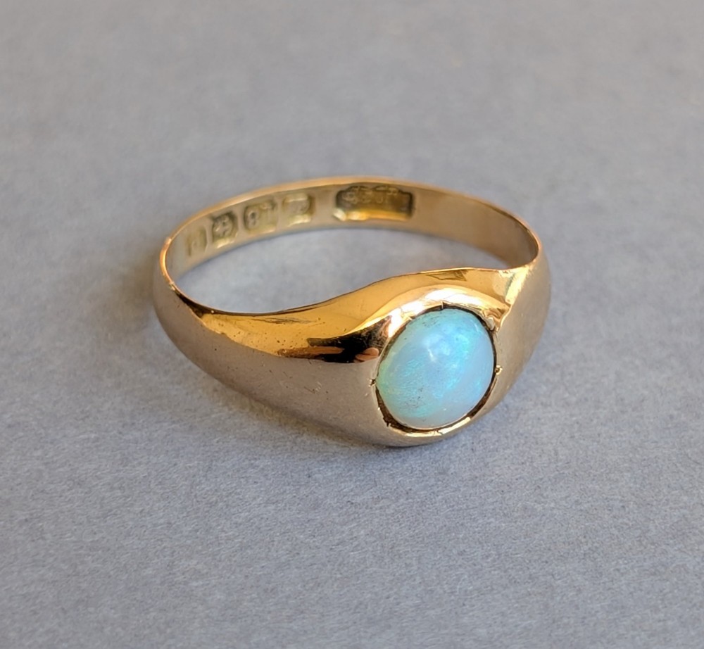 An antique yellow gold gypsy ring featuring a central round cabochon opal with blue and orange play-of-colour. View VII
