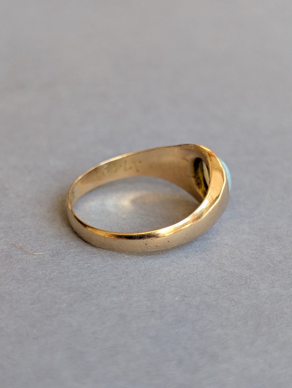 An antique yellow gold gypsy ring featuring a central round cabochon opal with blue and orange play-of-colour. View X