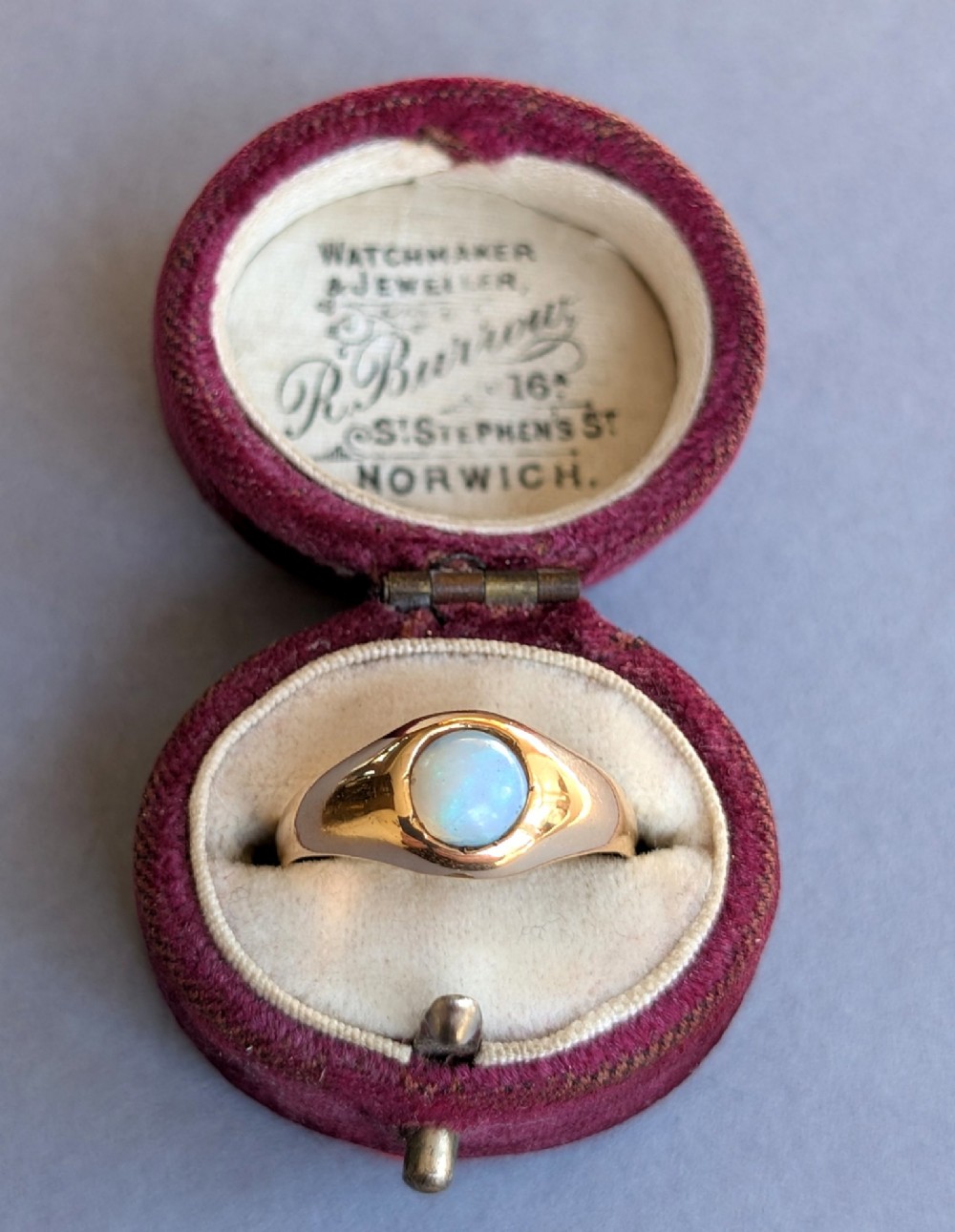 An antique yellow gold gypsy ring featuring a central round cabochon opal with blue and orange play-of-colour. View XI