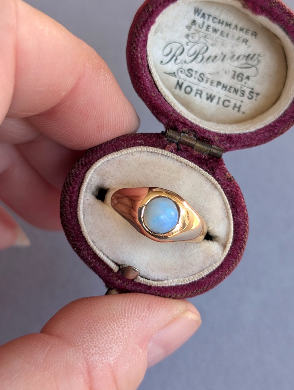 An antique yellow gold gypsy ring featuring a central round cabochon opal with blue and orange play-of-colour. View XIII