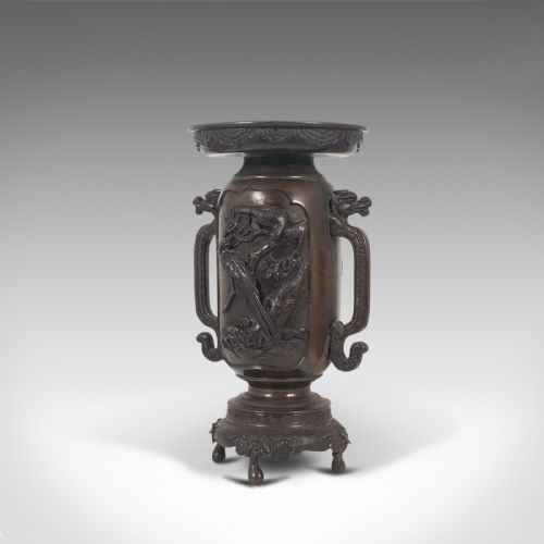 fig 2. A dark brown bronze Japanese Meiji period vase featuring relief carving of a bird on a branch, ornate handles, and a pedestal base.