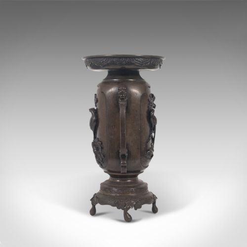 fig 3. A dark brown bronze Japanese Meiji period vase featuring relief carving of a bird on a branch, ornate handles, and a pedestal base.