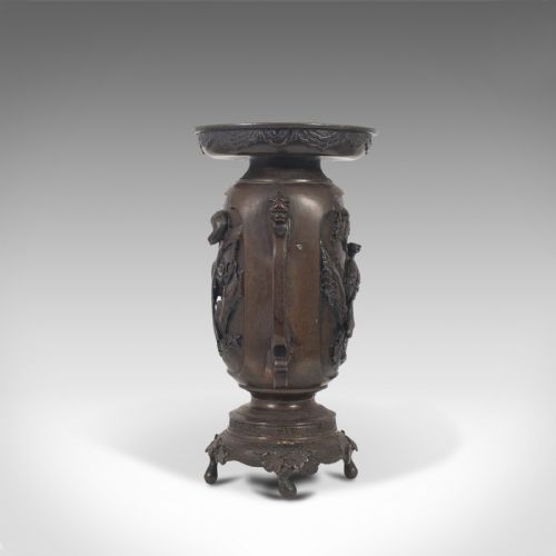 fig 4. A dark brown bronze Japanese Meiji period vase featuring relief carving of a bird on a branch, ornate handles, and a pedestal base.