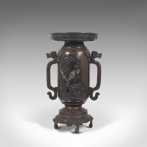 fig 5. A dark brown bronze Japanese Meiji period vase featuring relief carving of a bird on a branch, ornate handles, and a pedestal base.