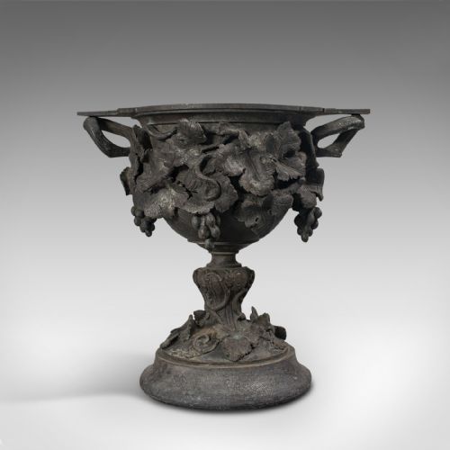 fig 1. An 18th-century Continental dark bronze serving cup featuring detailed grapevine relief carving, twin side handles, and a flared pedestal base.