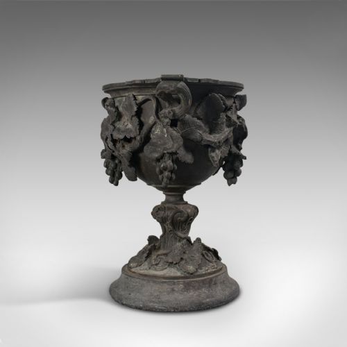 fig 3. An 18th-century Continental dark bronze serving cup featuring detailed grapevine relief carving, twin side handles, and a flared pedestal base.