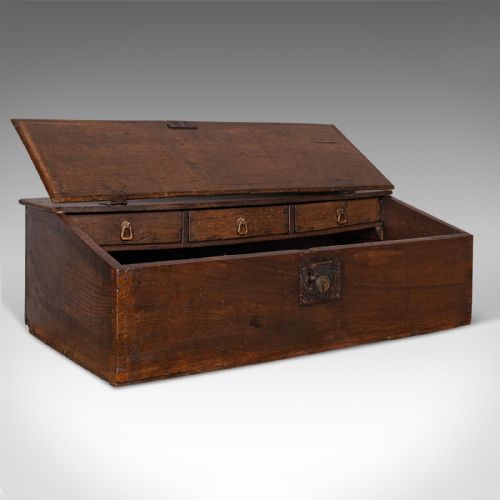 fig 1. A dark brown antique oak tabletop writing desk featuring a sloped hinged lid with studded initials and a metal front lockplate.