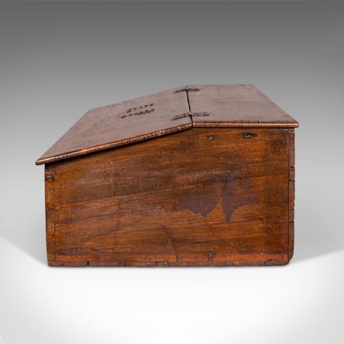 fig 3. A dark brown antique oak tabletop writing desk featuring a sloped hinged lid with studded initials and a metal front lockplate.