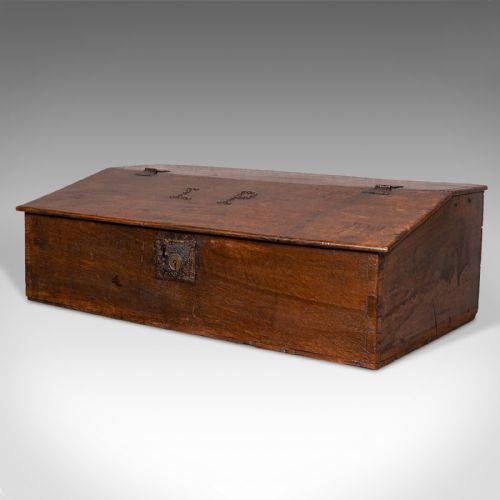 fig 4. A dark brown antique oak tabletop writing desk featuring a sloped hinged lid with studded initials and a metal front lockplate.