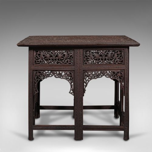 fig 1. A dark brown carved teak folding occasional table featuring intricate floral openwork panels and arches.