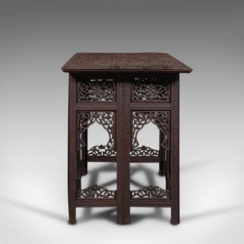 fig 2. A dark brown carved teak folding occasional table featuring intricate floral openwork panels and arches.