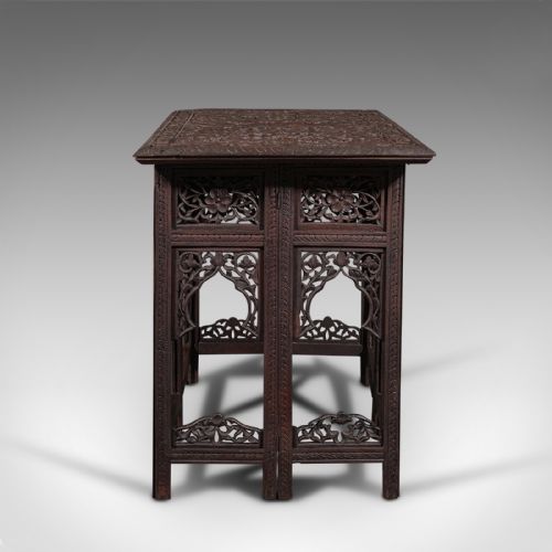 fig 3. A dark brown carved teak folding occasional table featuring intricate floral openwork panels and arches.