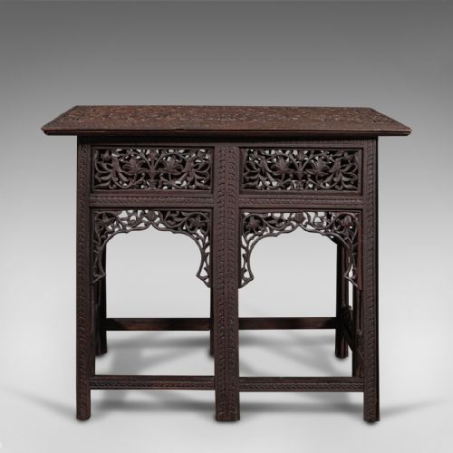 fig 4. A dark brown carved teak folding occasional table featuring intricate floral openwork panels and arches.
