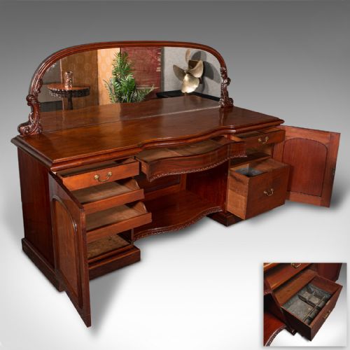 fig 4. A Victorian flame mahogany pedestal sideboard featuring a large arched mirror back with carved scroll supports above twin panelled pedestal cupboards.