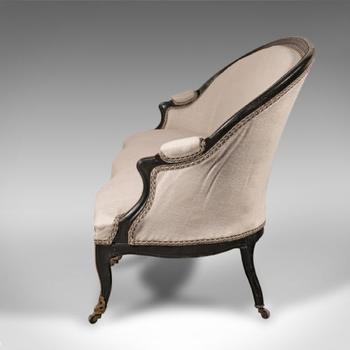 fig 3. A 19th-century Continental Louis XV style ebonised settee upholstered in neutral linen with gilt accents and cabriole legs on castors.