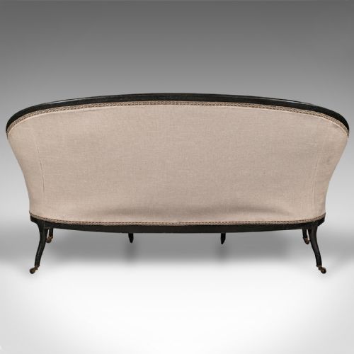 fig 4. A 19th-century Continental Louis XV style ebonised settee upholstered in neutral linen with gilt accents and cabriole legs on castors.