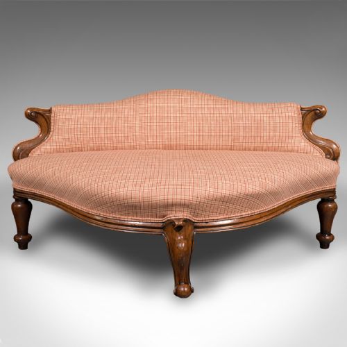 fig 1. A Victorian asymmetrical walnut love seat featuring a carved wood frame and red patterned fabric upholstery.