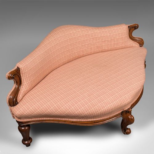 fig 5. A Victorian asymmetrical walnut love seat featuring a carved wood frame and red patterned fabric upholstery.