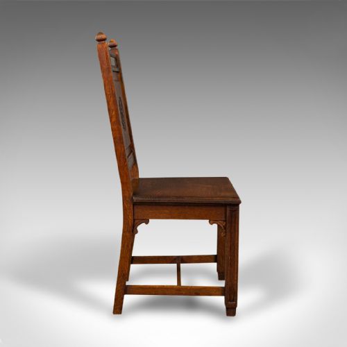 fig 2. A pair of antique Victorian English oak hall chairs featuring carved IHS monograms on the backrests and solid wooden seats.