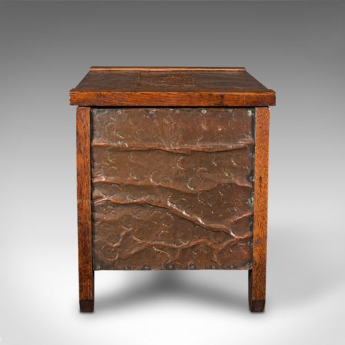 fig 3. An Edwardian oak coal keeper featuring an open hinged lid and textured hammered copper panels mounted within a solid wooden frame.