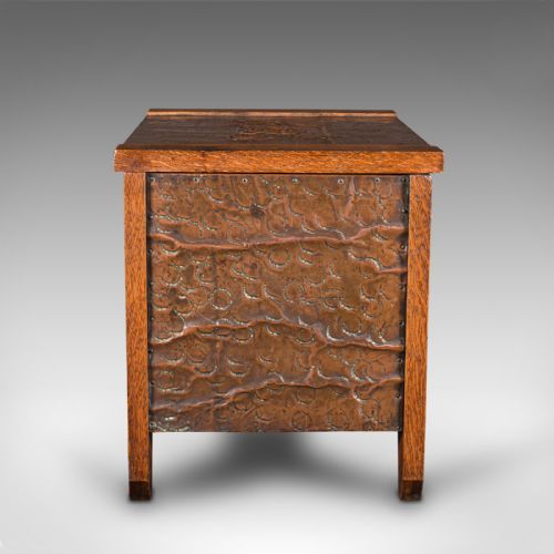 fig 4. An Edwardian oak coal keeper featuring an open hinged lid and textured hammered copper panels mounted within a solid wooden frame.