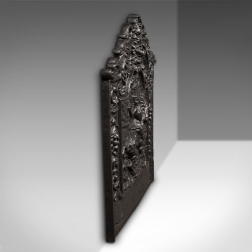 fig 2. A dark cast iron Georgian fireback decorated with an equestrian relief figure surrounded by detailed foliate and scroll cresting.
