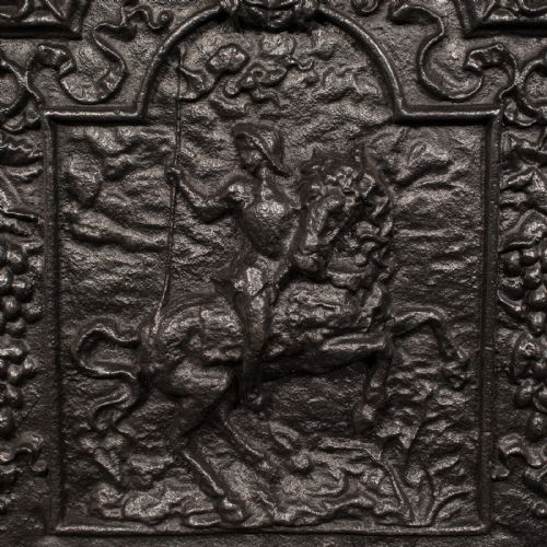fig 3. A dark cast iron Georgian fireback decorated with an equestrian relief figure surrounded by detailed foliate and scroll cresting.