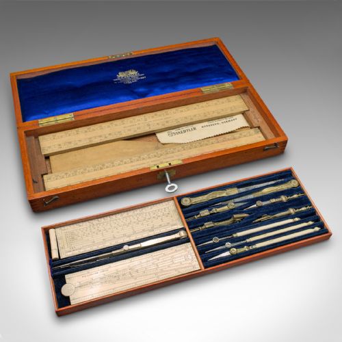 fig 1. An open Edwardian mahogany case displaying brass drawing instruments, rules, and pens resting on a blue velvet lining.