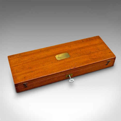 fig 2. An open Edwardian mahogany case displaying brass drawing instruments, rules, and pens resting on a blue velvet lining.